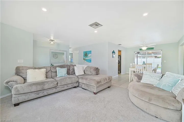 Carpeted living area featuring recessed lighting, a ceiling fan, and tile patterned floors