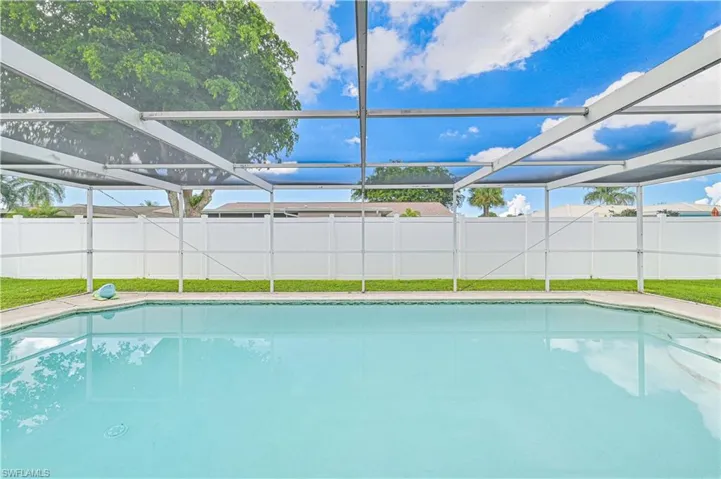 View of swimming pool featuring glass enclosure, a sunroom, and a fenced backyard