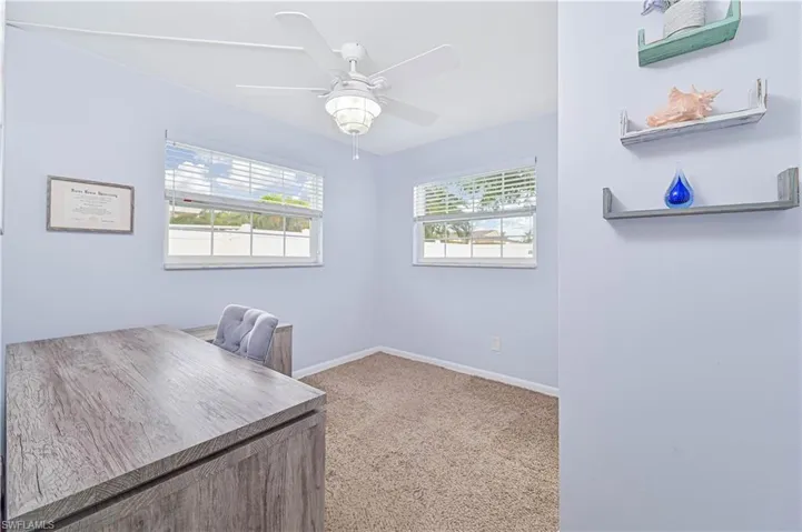 Office space with light colored carpet and a ceiling fan