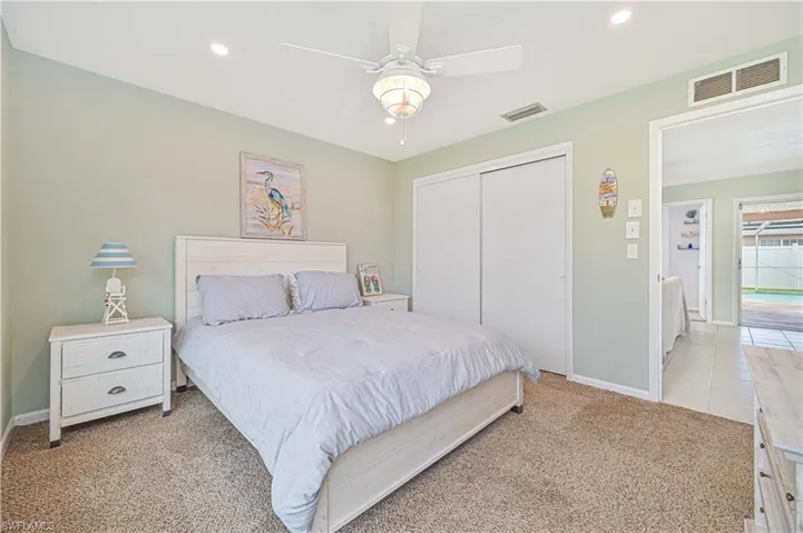 Bedroom with light carpet, a closet, a ceiling fan, and recessed lighting