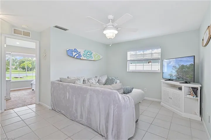 Living area with light tile patterned floors and a ceiling fan