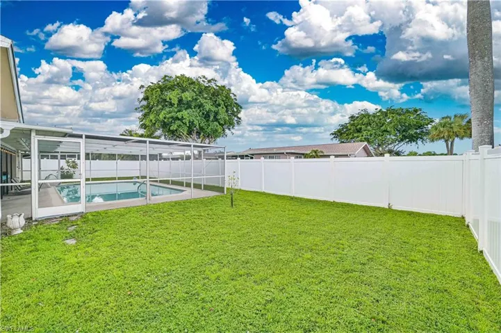 Fenced backyard featuring a sunroom and a patio area