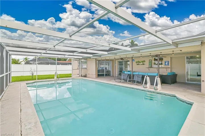 View of swimming pool with a sunroom, a ceiling fan, glass enclosure, a patio area, and outdoor lounge area