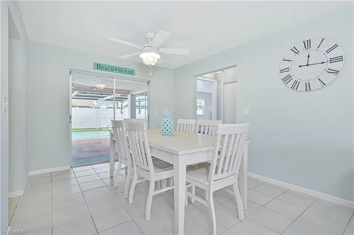 Dining area featuring light tile patterned floors, a sunroom, and ceiling fan