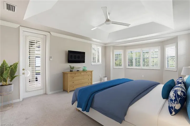 Carpeted bedroom with a raised ceiling, access to outside, a ceiling fan, and ornamental molding