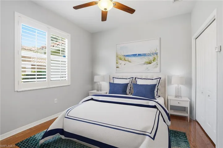Bedroom with wood finished floors, ceiling fan, and a closet