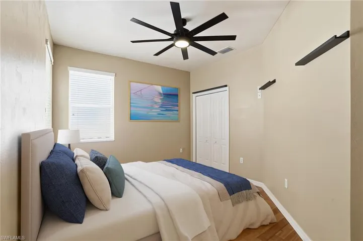 Bedroom featuring wood finished floors, a closet, and ceiling fan