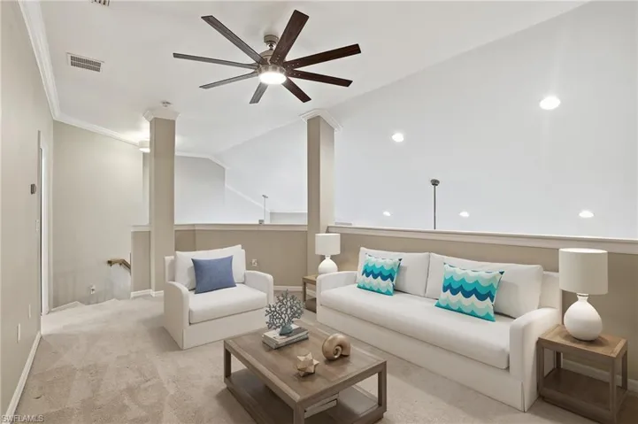 Carpeted living area featuring ceiling fan, lofted ceiling, crown molding, and recessed lighting