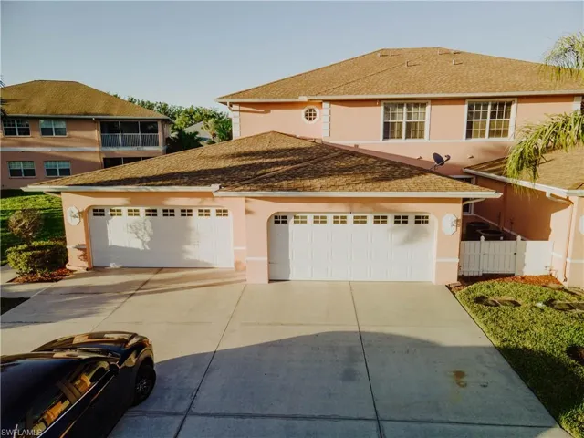 View of front facade featuring stucco siding, driveway, a garage, and a shingled roof