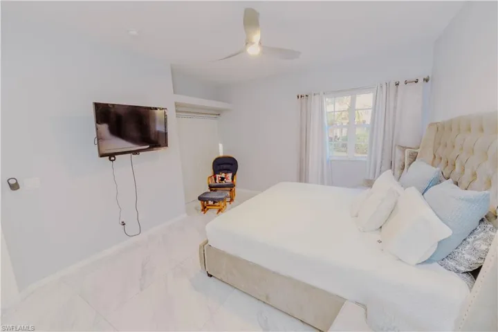 Bedroom featuring ceiling fan and light marble finish floors