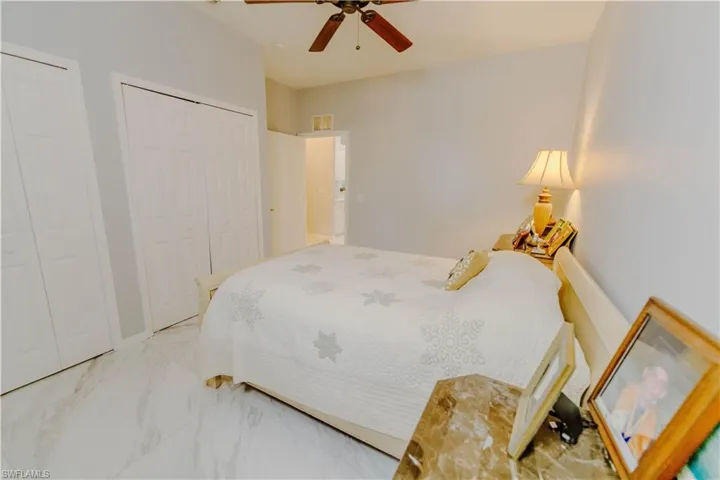Bedroom with ceiling fan and multiple closets