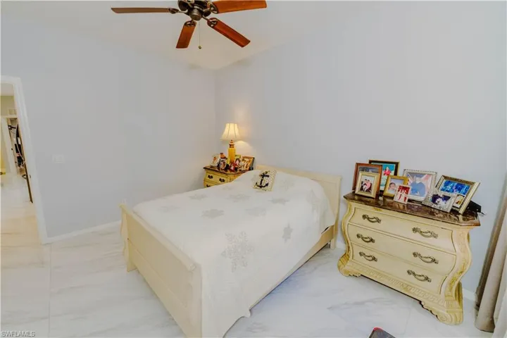 Bedroom with light marble finish floors and ceiling fan