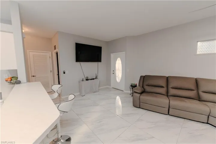 Living room featuring baseboards and light marble finish flooring