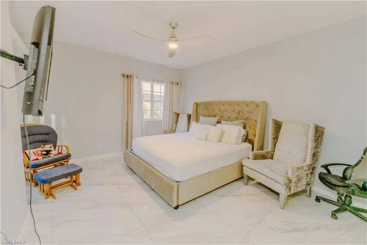 Bedroom featuring ceiling fan and marble finish flooring