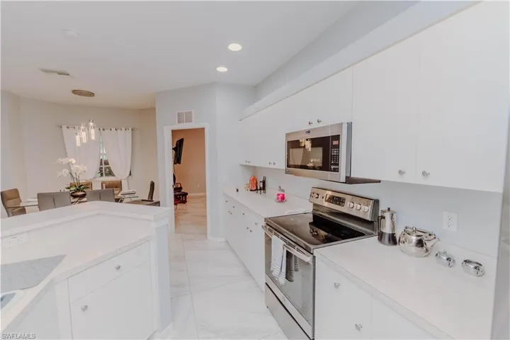 Kitchen with appliances with stainless steel finishes, light countertops, white cabinetry, and recessed lighting