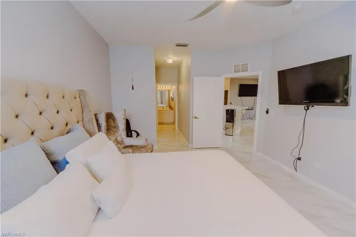 Bedroom with ensuite bath and a ceiling fan