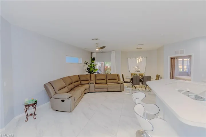 Living area featuring a ceiling fan and baseboards