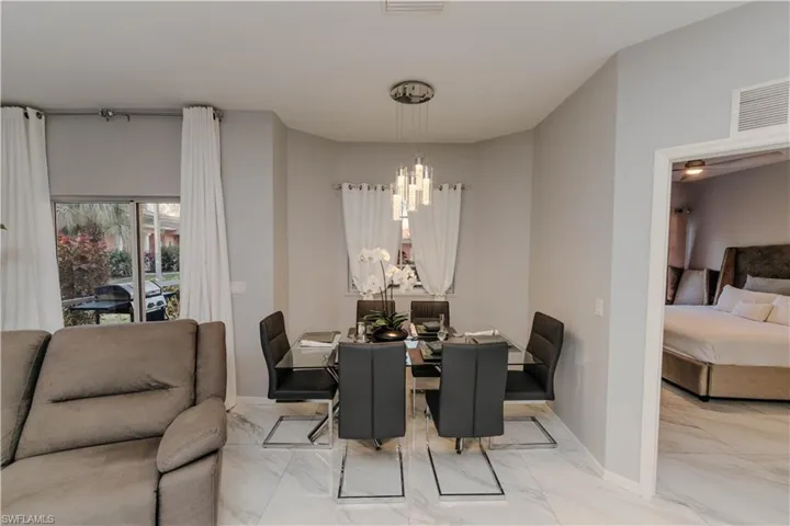 Dining space with baseboards and marble look tiles