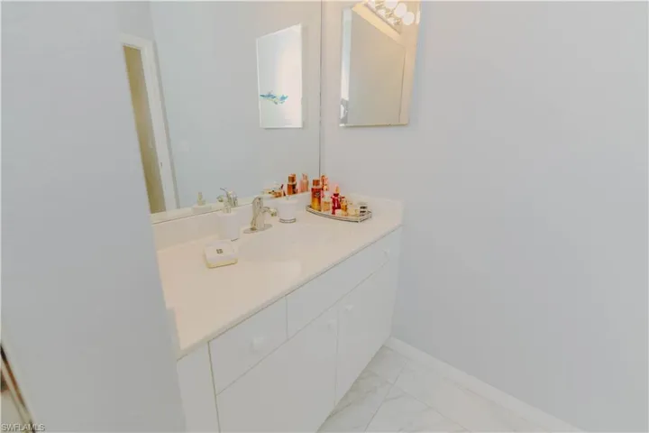 Bathroom featuring vanity and light marble finish floors