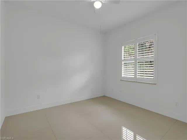 Guest Bedroom #2 with large tile flooring, closet and ceiling fan with lighting