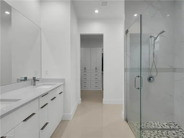 Primary Bathroom with dual sink, soft close cabinets and walk-in glass shower