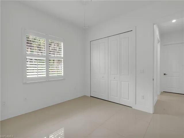 Guest Bedroom #2 with large tile flooring, closet and ceiling fan with lighting
