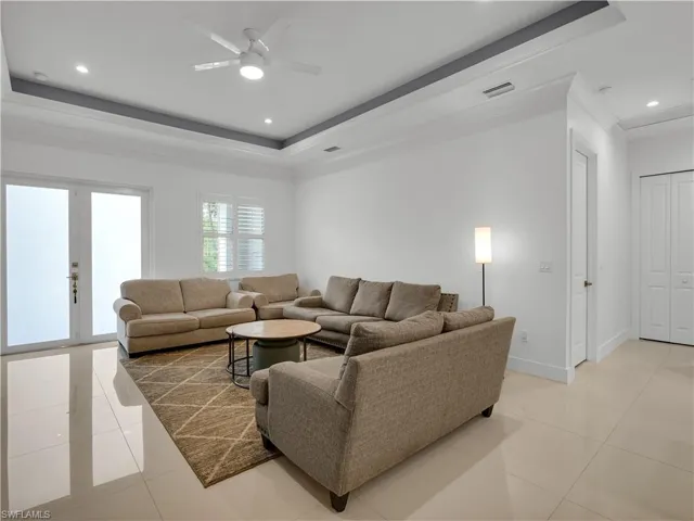 Living Room large tile flooring, tray-ceiling and ceiling fan with lighting
