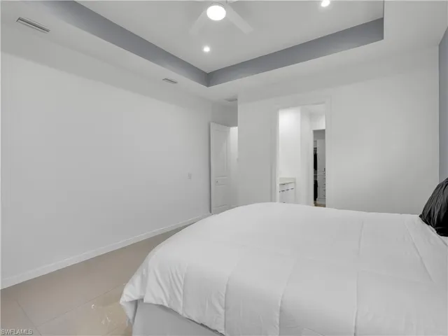 Primary Bedroom Primary Bedroom with large tile flooring, ceiling fan, and tray ceiling