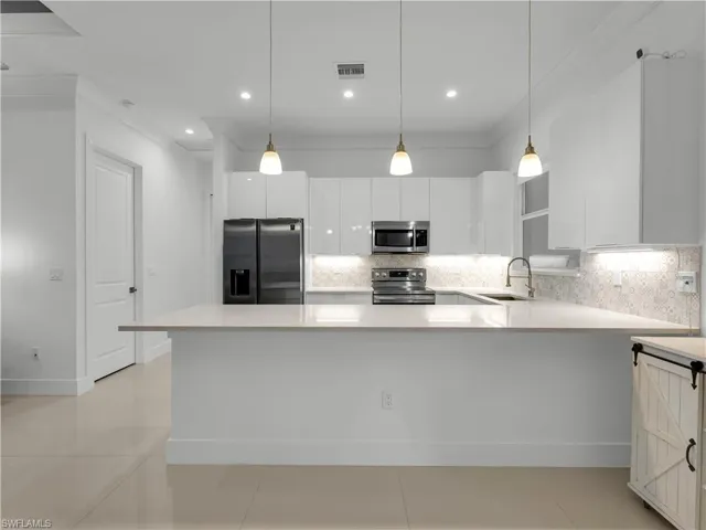 Kitchen with lighting fixture and breakfast bar