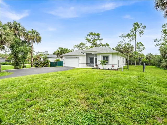Front of the home with paved driveway and fenced in yard
