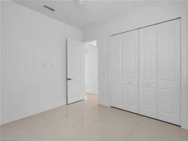 Guest Bedroom #3 with large tile flooring, closet and ceiling fan with lighting
