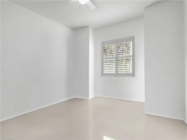 Guest Bedroom #1 with large tile flooring and ceiling fan with lighting