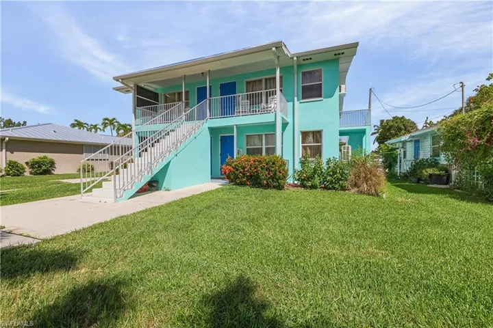 View of front of home with a balcony and a front yard