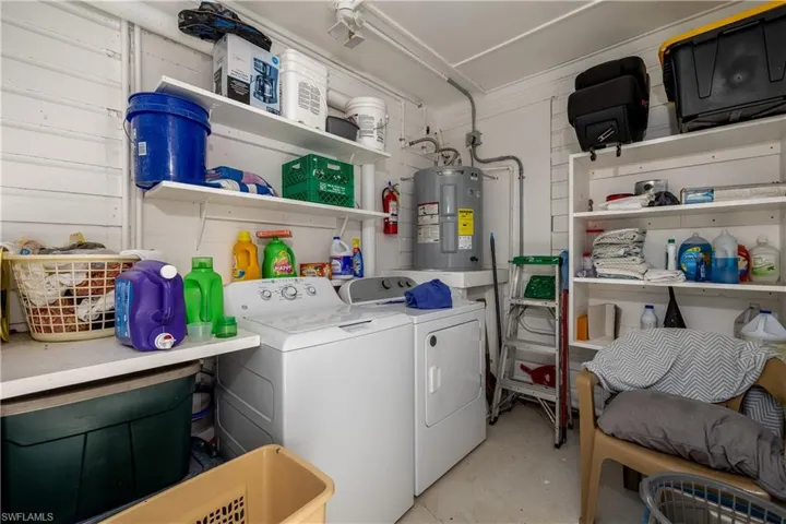 Laundry room with water heater and washing machine and dryer