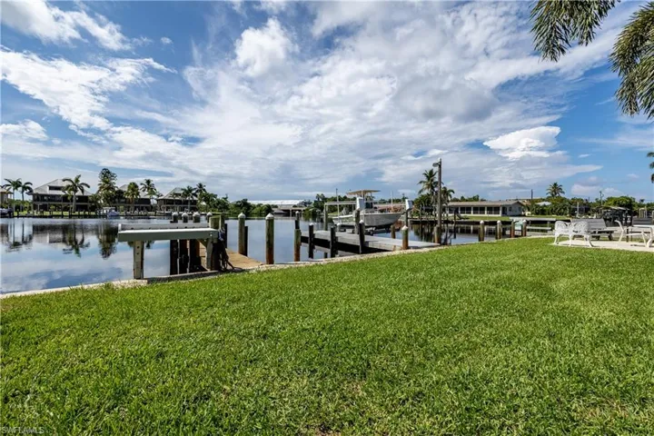Dock area with a lawn and a water view