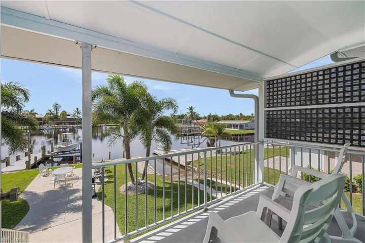 Balcony featuring a boat dock and a water view