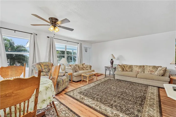 Living room featuring wood-type flooring, ceiling fan, and a textured ceiling