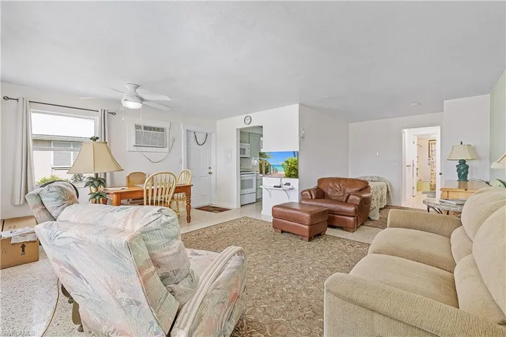 Living room with ceiling fan and a wall unit AC