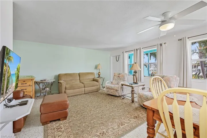 Living room with ceiling fan and a textured ceiling