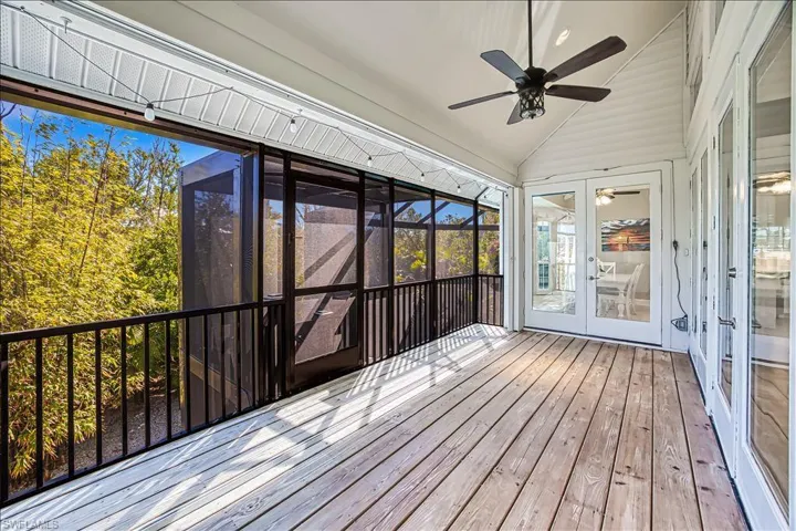 Unfurnished sunroom featuring lofted ceiling, ceiling fan, and french doors