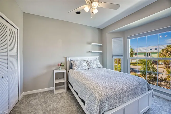 Bedroom featuring light carpet, a closet, and ceiling fan