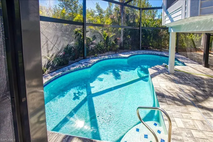 View of swimming pool with a patio and a lanai
