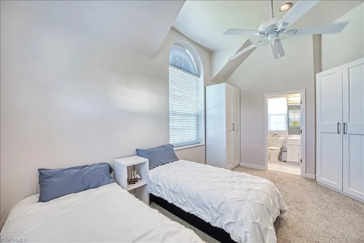 Carpeted bedroom with ceiling fan and ensuite bath
