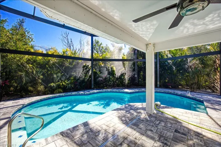 View of pool with a patio and glass enclosure