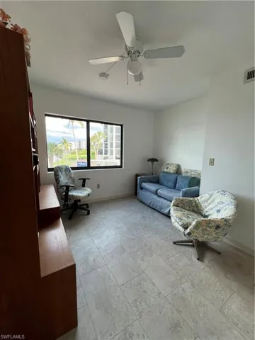 Living room featuring ceiling fan and light tile patterned floors