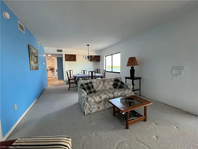 Living room featuring a chandelier and light colored carpet