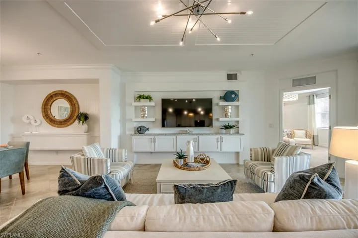 Living room featuring ornamental molding and an inviting chandelier