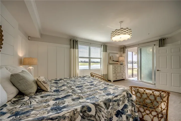 Carpeted bedroom with ornamental molding and access to exterior