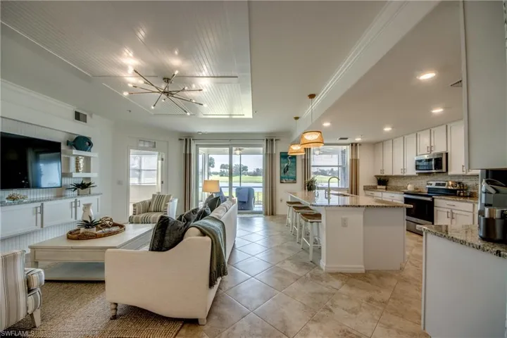 Tiled living room featuring sink, a chandelier, and ornamental molding