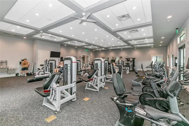 Exercise room with equipment, ceiling fan, high ceilings,